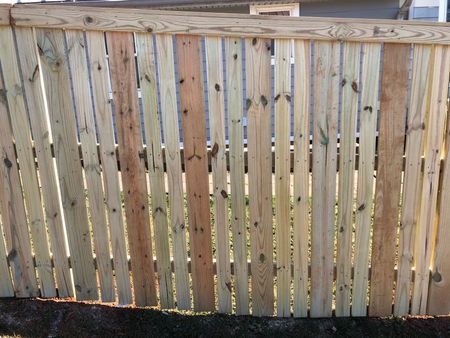 Stone pathway leading uphill through a yard, past an air conditioner and into woods.