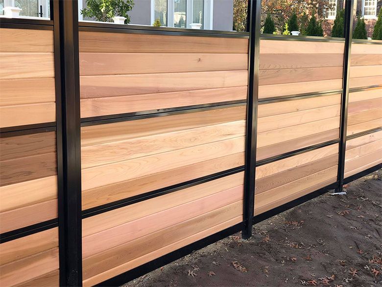 Wooden privacy fence with vertical boards and diagonal supports, outdoors.