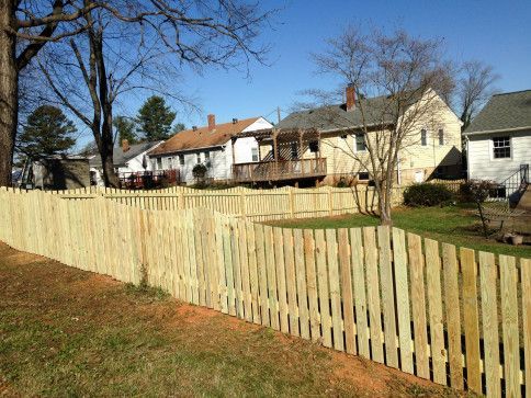 Wooden fence in front of houses; sunny day.