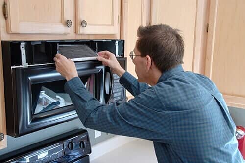 Technician Repairing the Fan over a Microwave and Oven - Appliance Services and Repair in Worth, IL