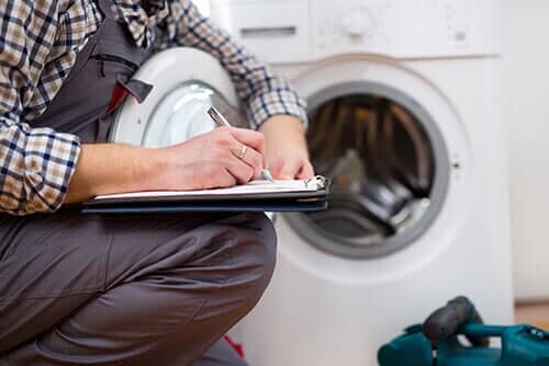 Repairman Entering malfunction of a Washing Machine - Appliance Service and Repair in Worth, IL