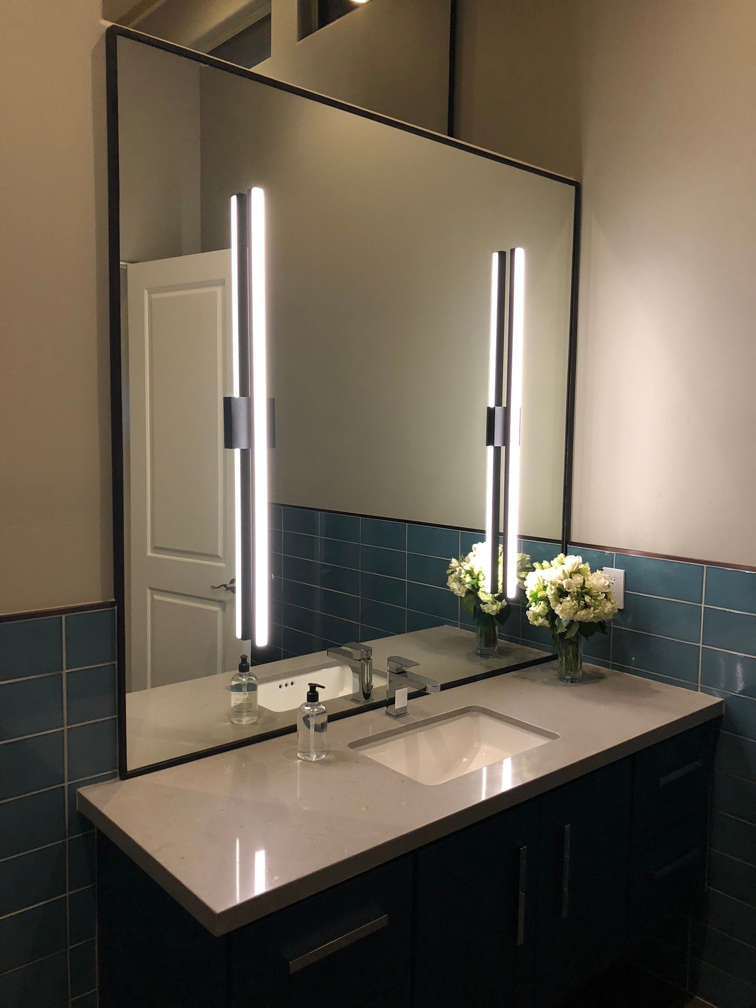 A bathroom with a large mirror and a sink