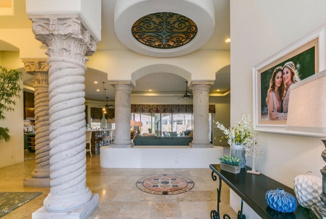 A large room with columns and a picture on the wall.