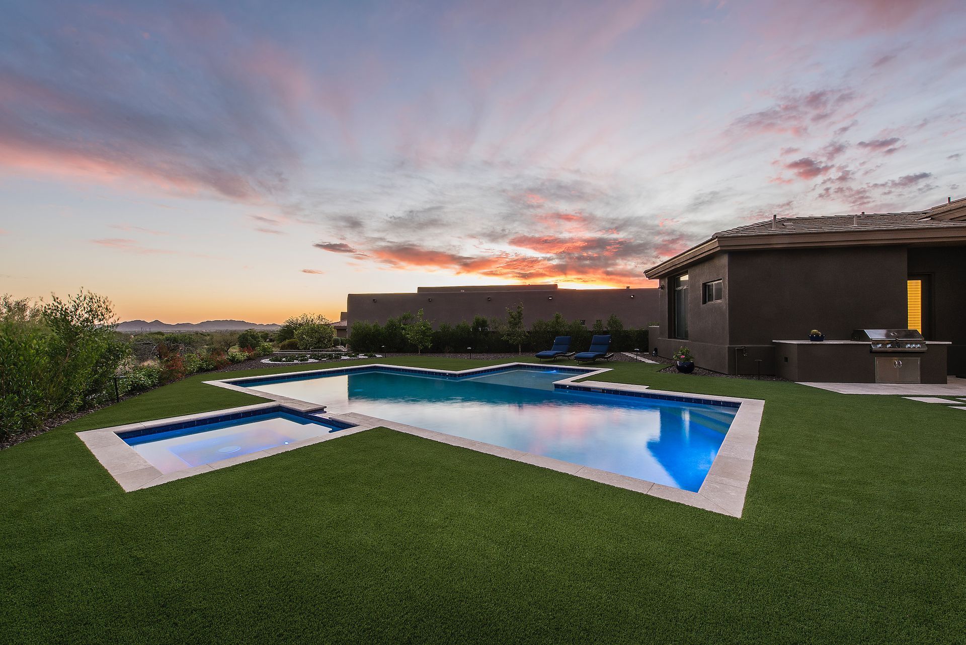 There is a large swimming pool in the backyard of a house.