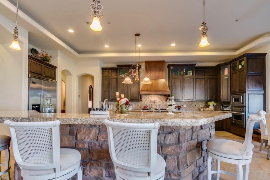 A kitchen with a large island and stools.