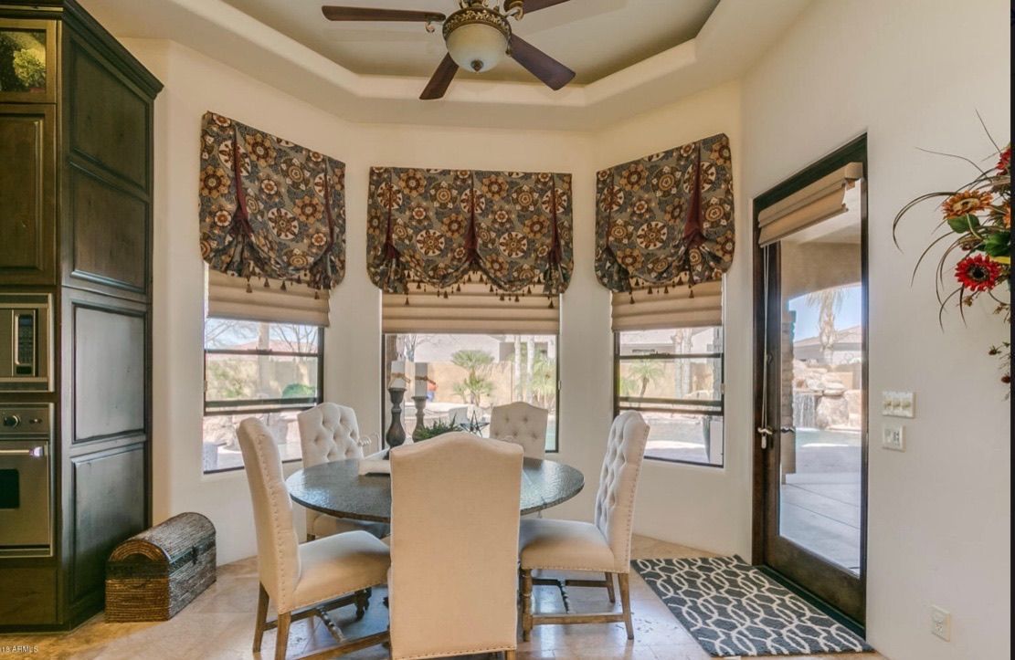 A dining room with a table and chairs and a ceiling fan