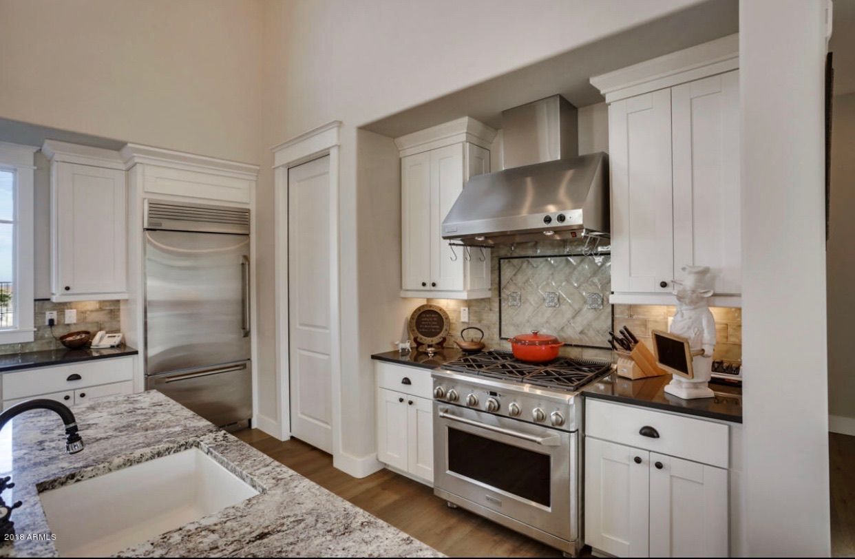 A kitchen with white cabinets and stainless steel appliances