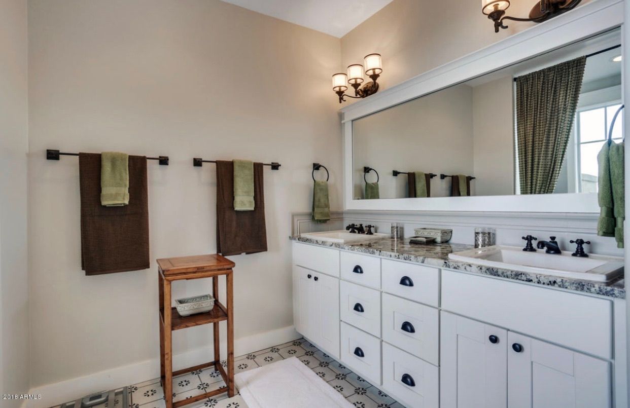A bathroom with two sinks and a large mirror