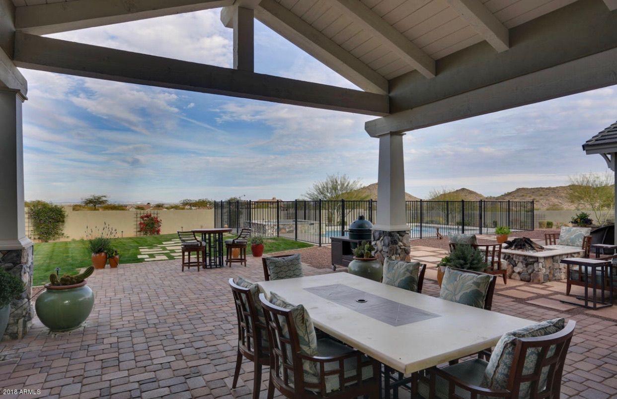 A patio with a table and chairs under a canopy.