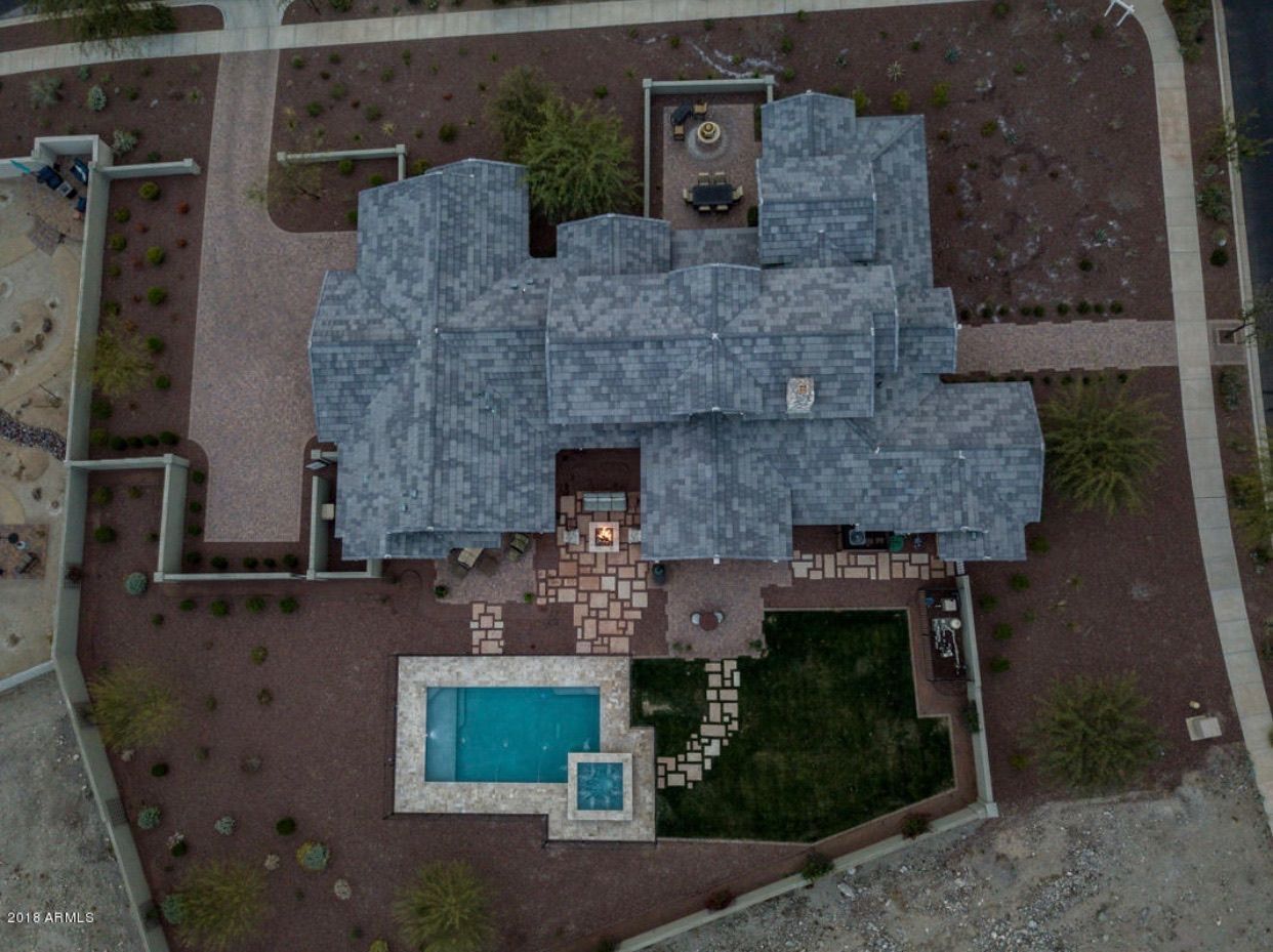 An aerial view of a large house with a pool in the backyard.