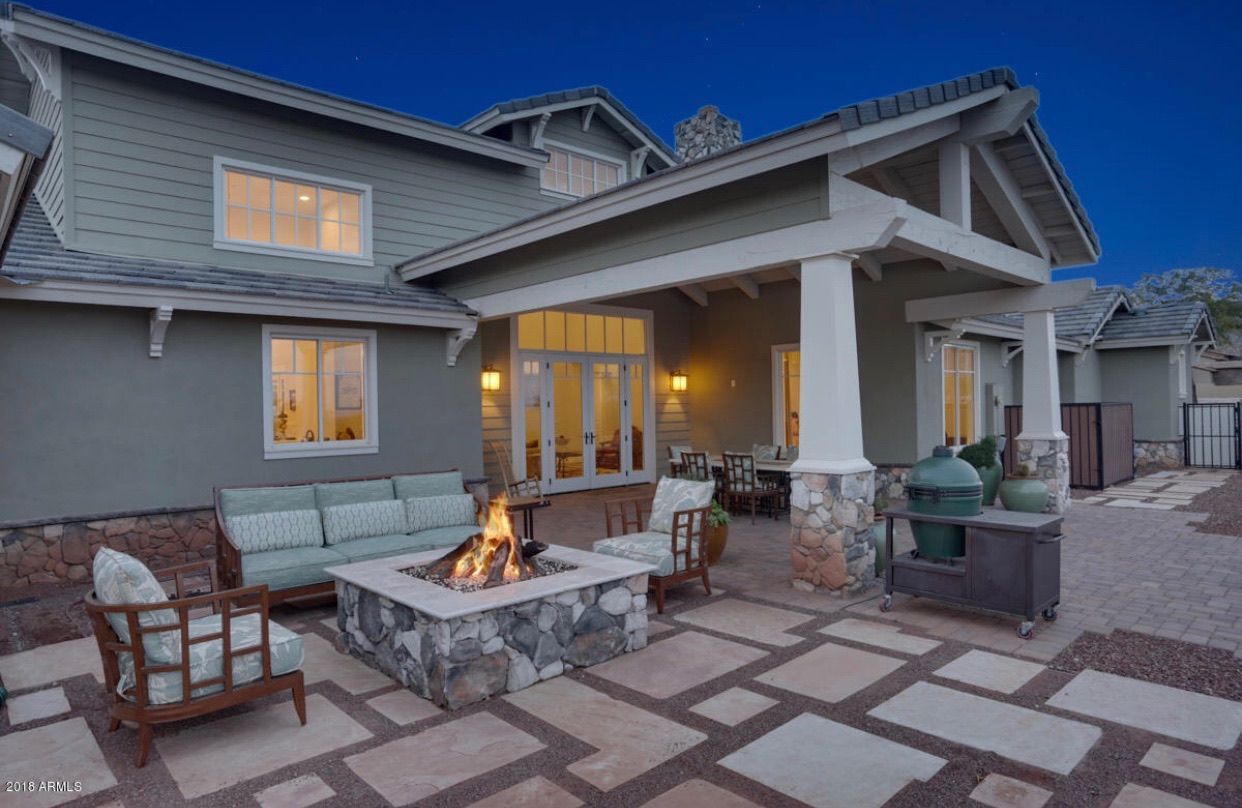 There is a fire pit in the backyard of a house.