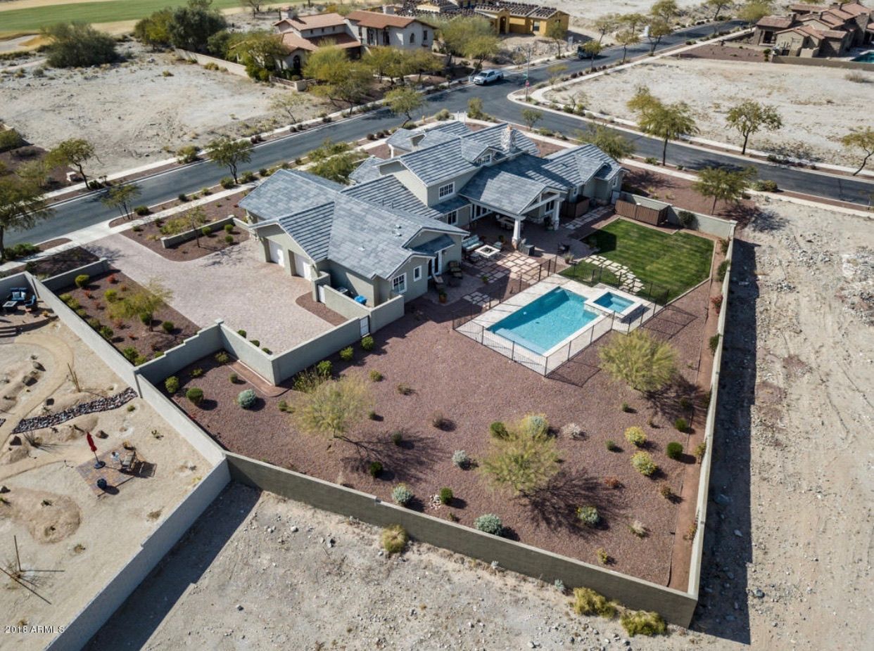 An aerial view of a house with a pool in the backyard