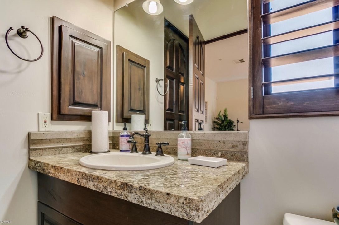 A bathroom with a sink , mirror and toilet.