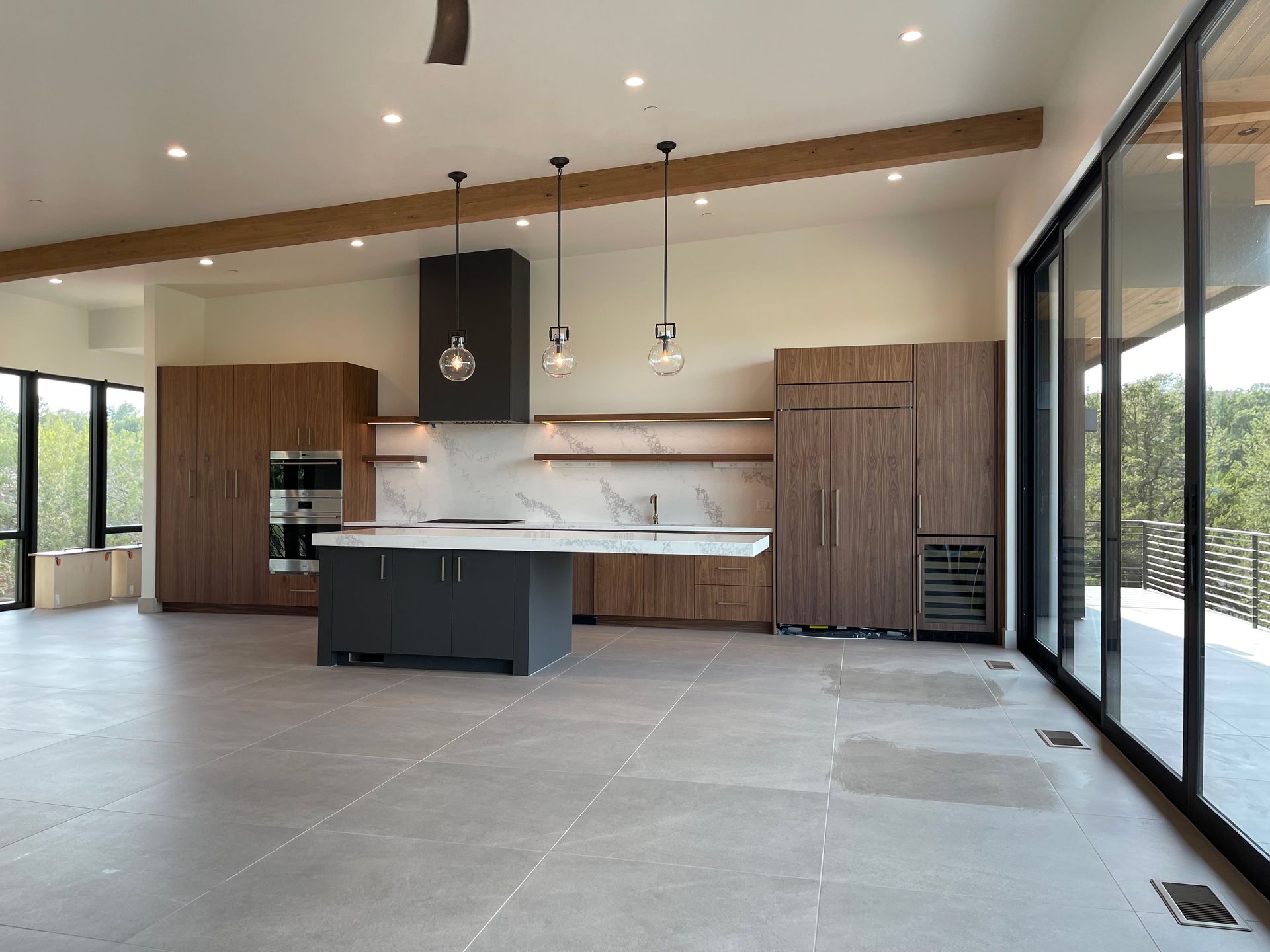 An empty kitchen with a large island in the middle of the room.
