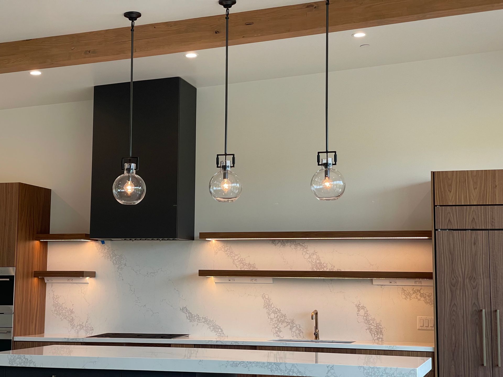 A kitchen with three pendant lights hanging from the ceiling.
