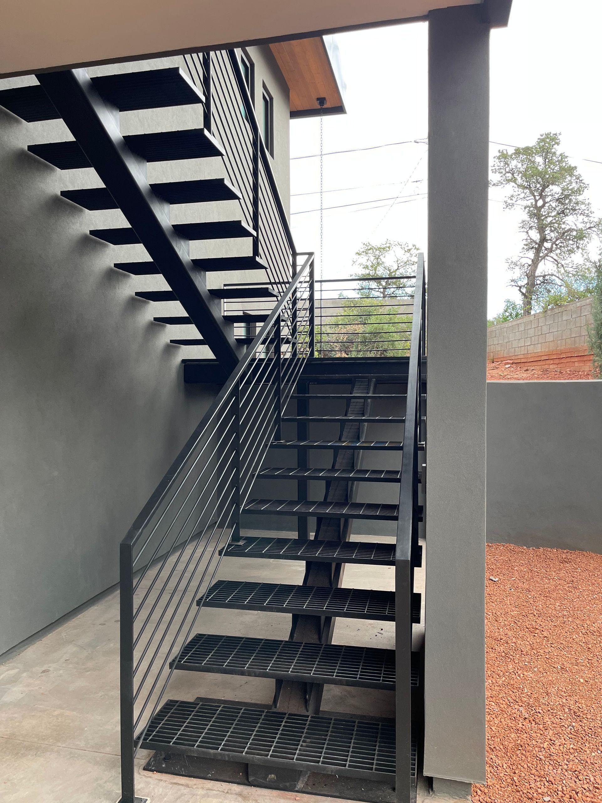 A black metal staircase leading up to the second floor of a building.
