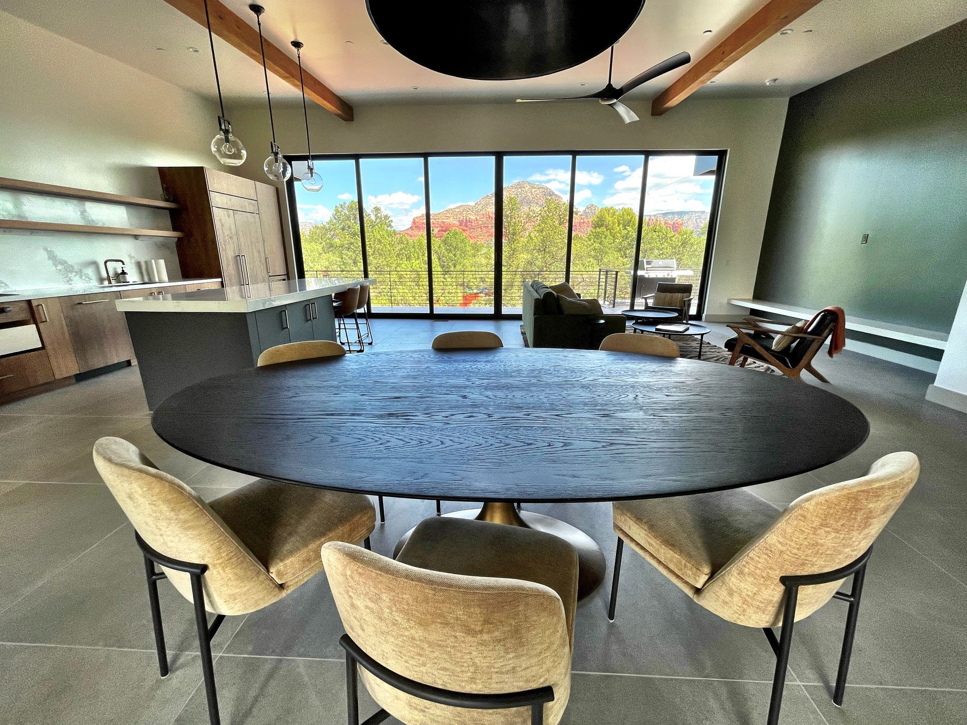 A dining room with a round table and chairs and a large window.