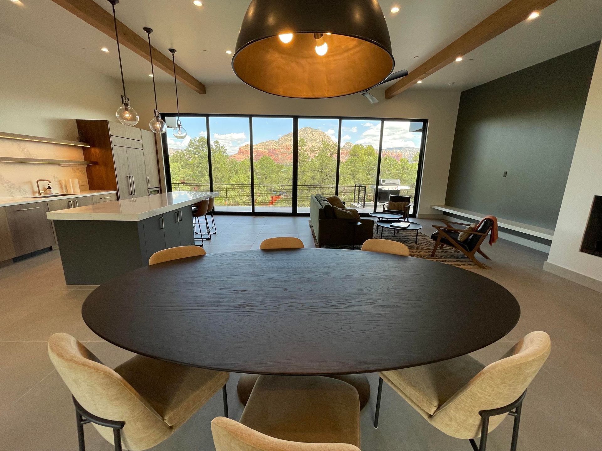 A dining room with a round table and chairs and a large window.