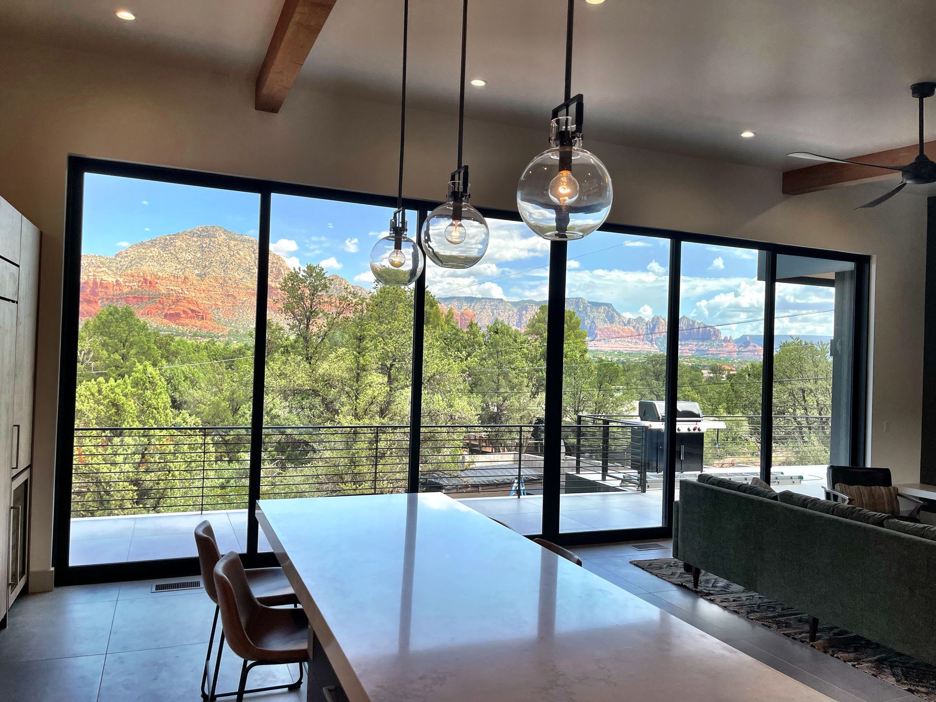 A kitchen with a large table and chairs and a view of a mountain.