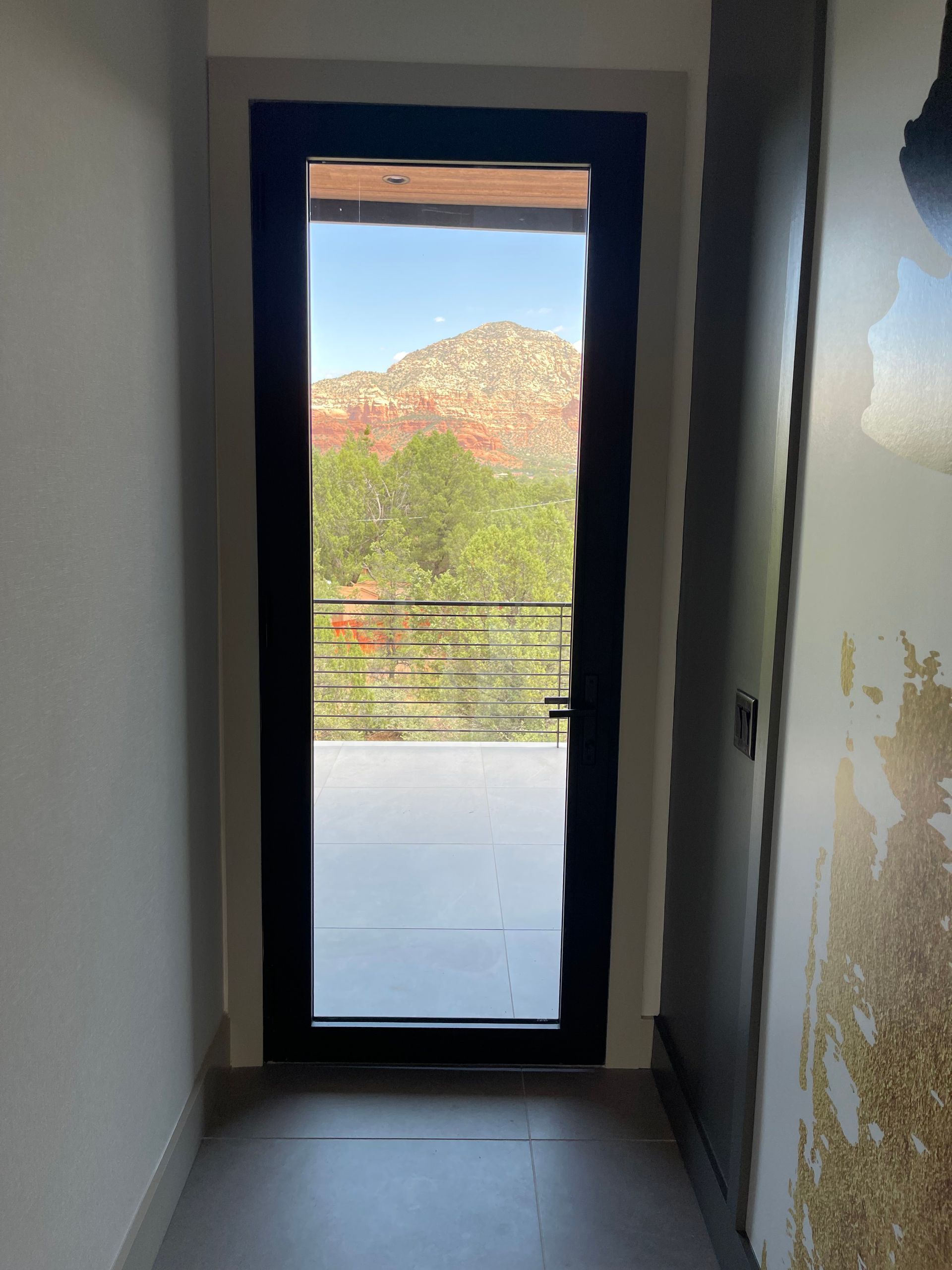 A hallway with a glass door and a view of a mountain.