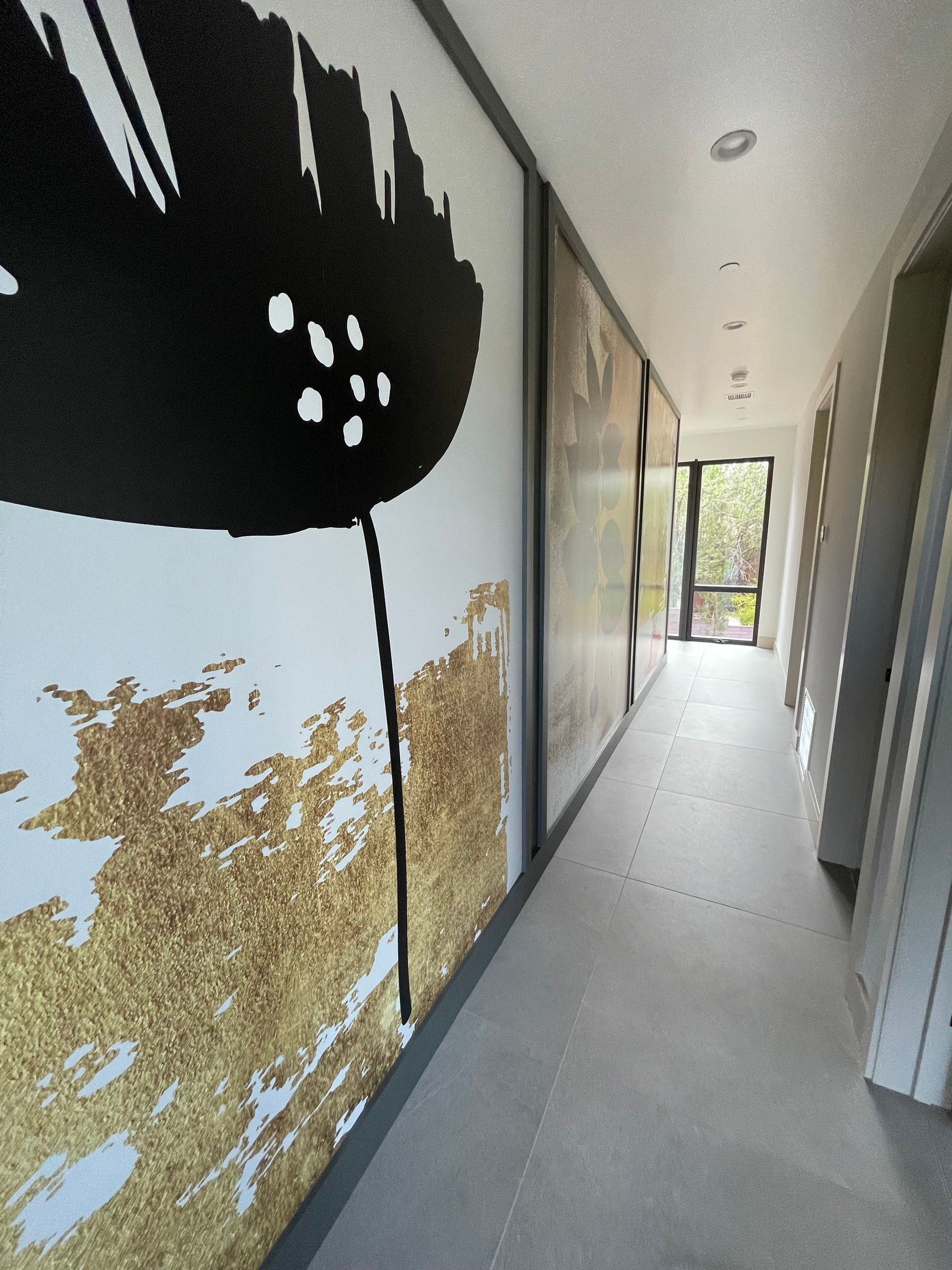 A hallway with a black and white painting on the wall