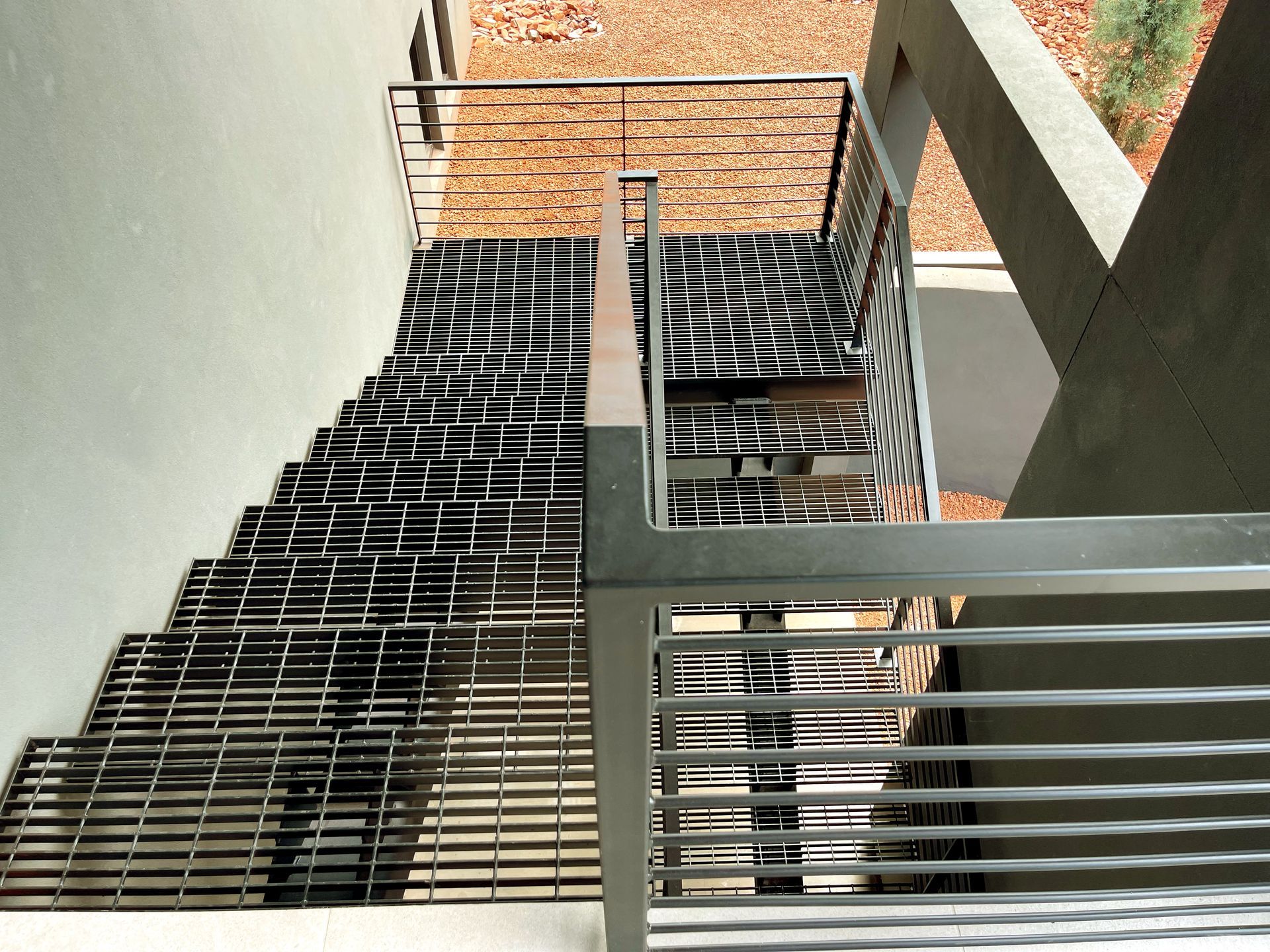 A staircase with a metal railing leading up to a balcony