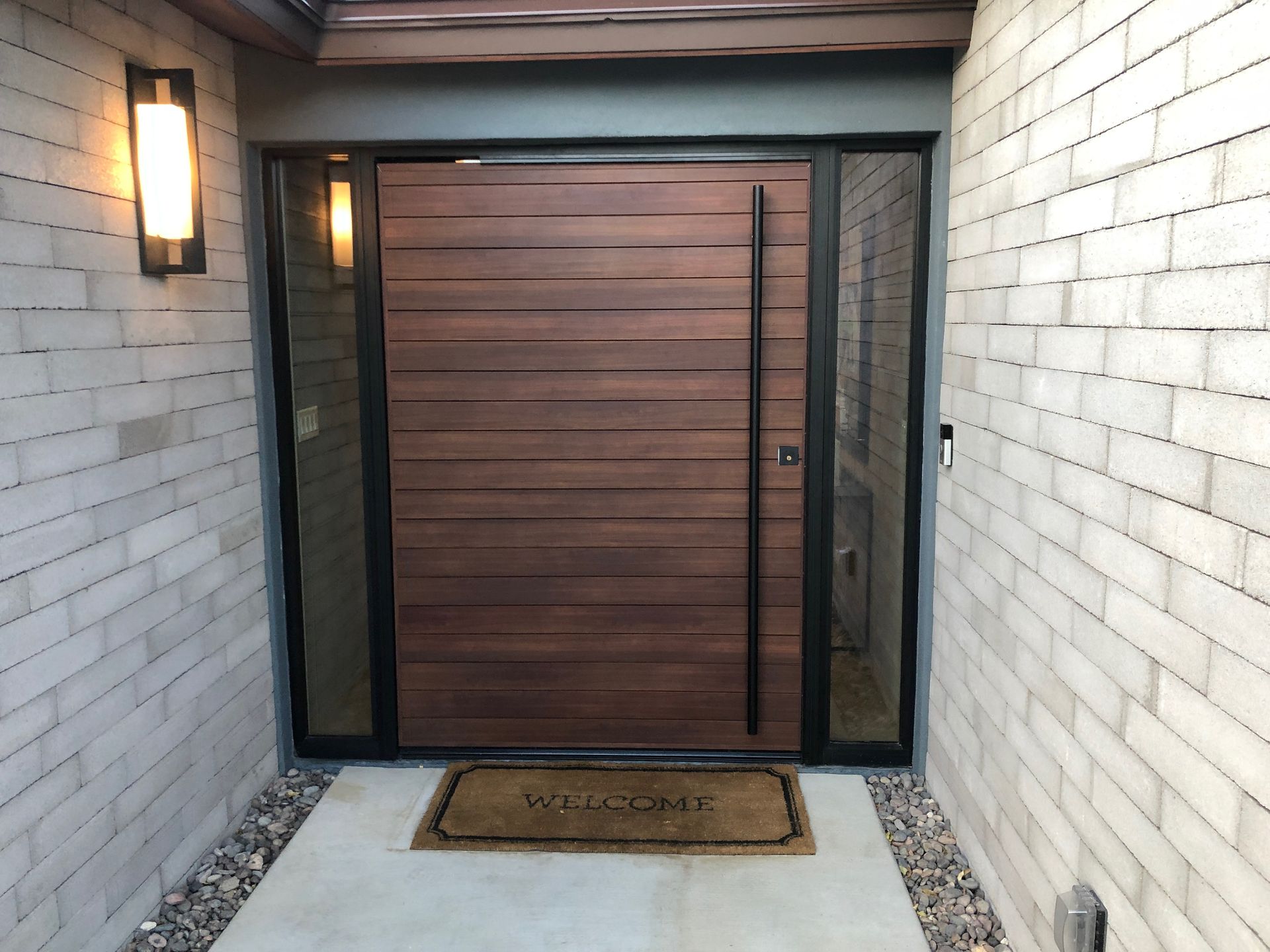 A wooden door with a welcome mat in front of it