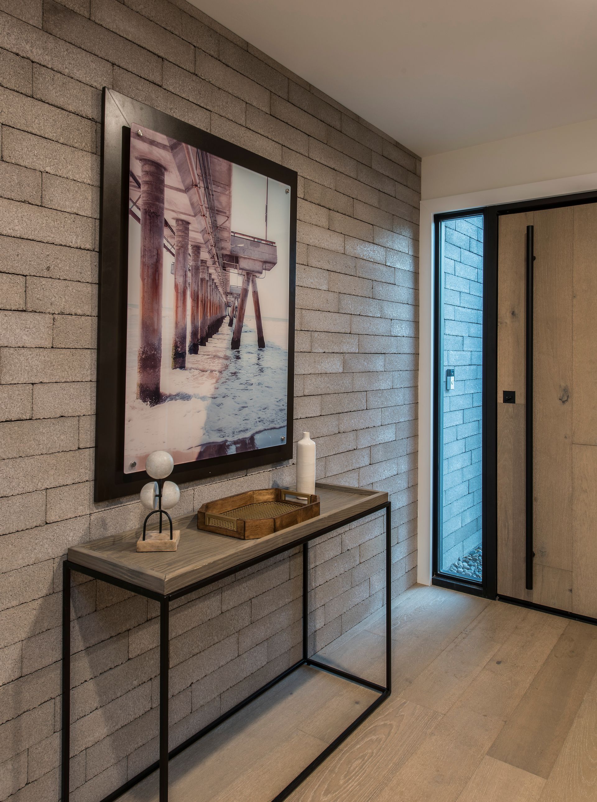 A hallway with a table and a picture on the wall