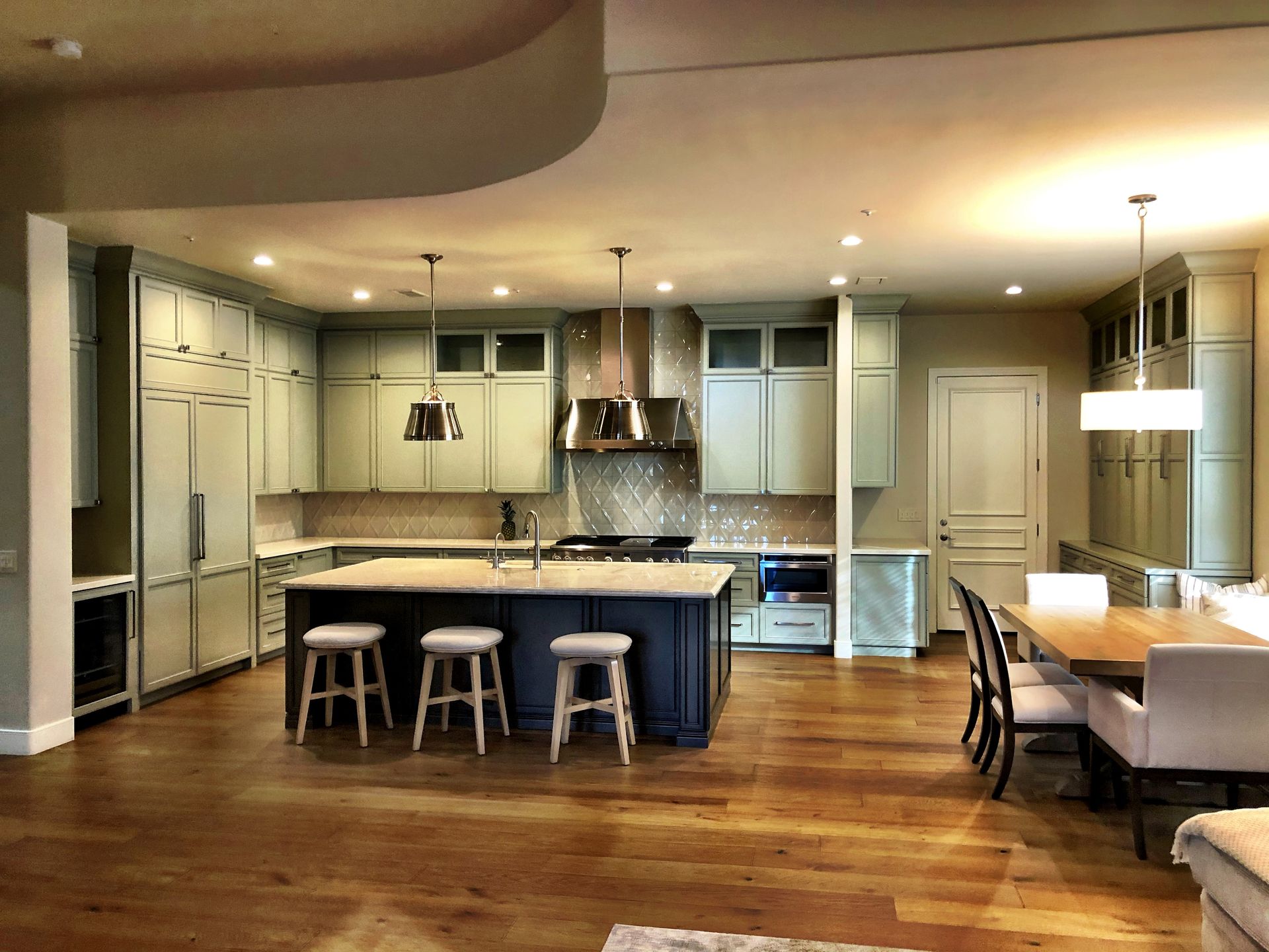 A kitchen with a large island and stools in it