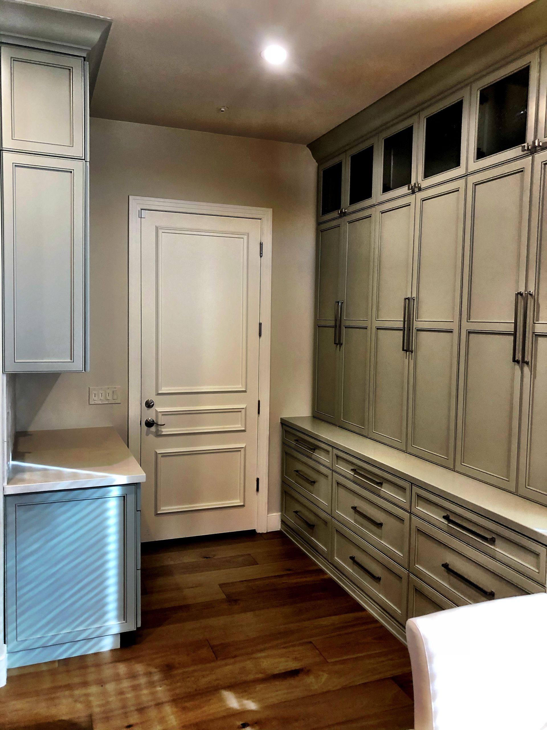 A room with lots of cabinets and drawers and a door.