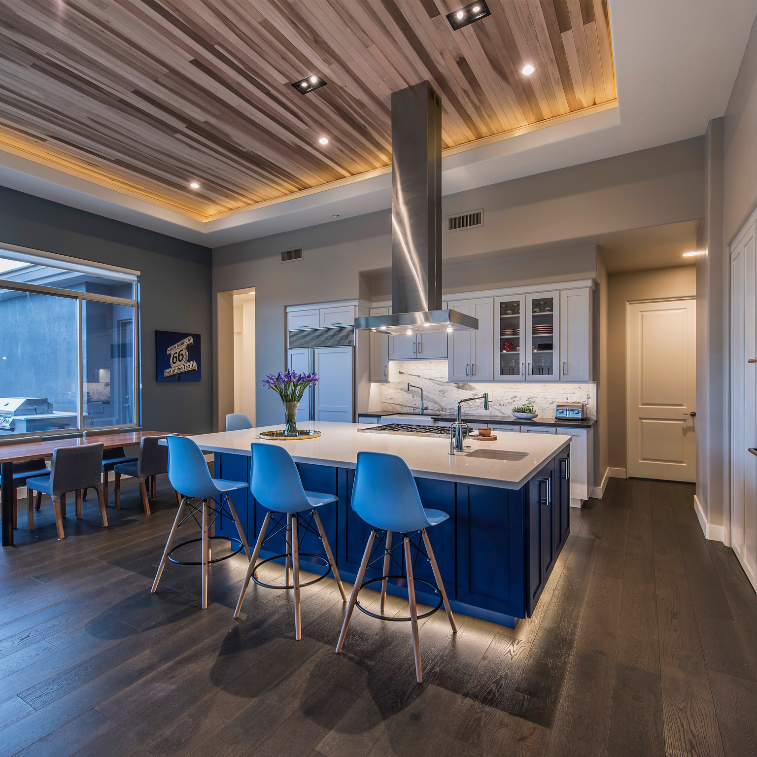 A kitchen with a large blue island and stools