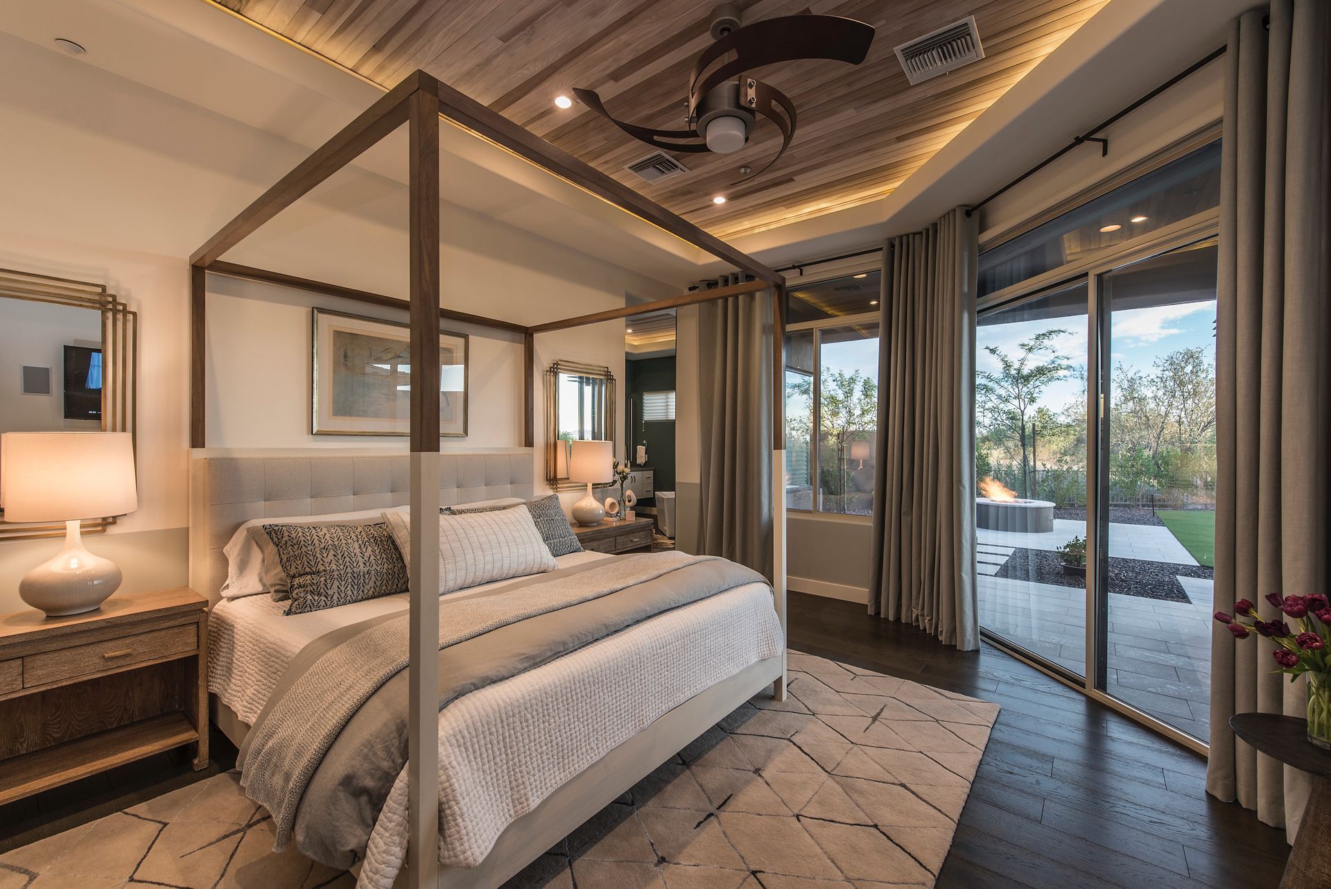 A bedroom with a canopy bed and sliding glass doors.