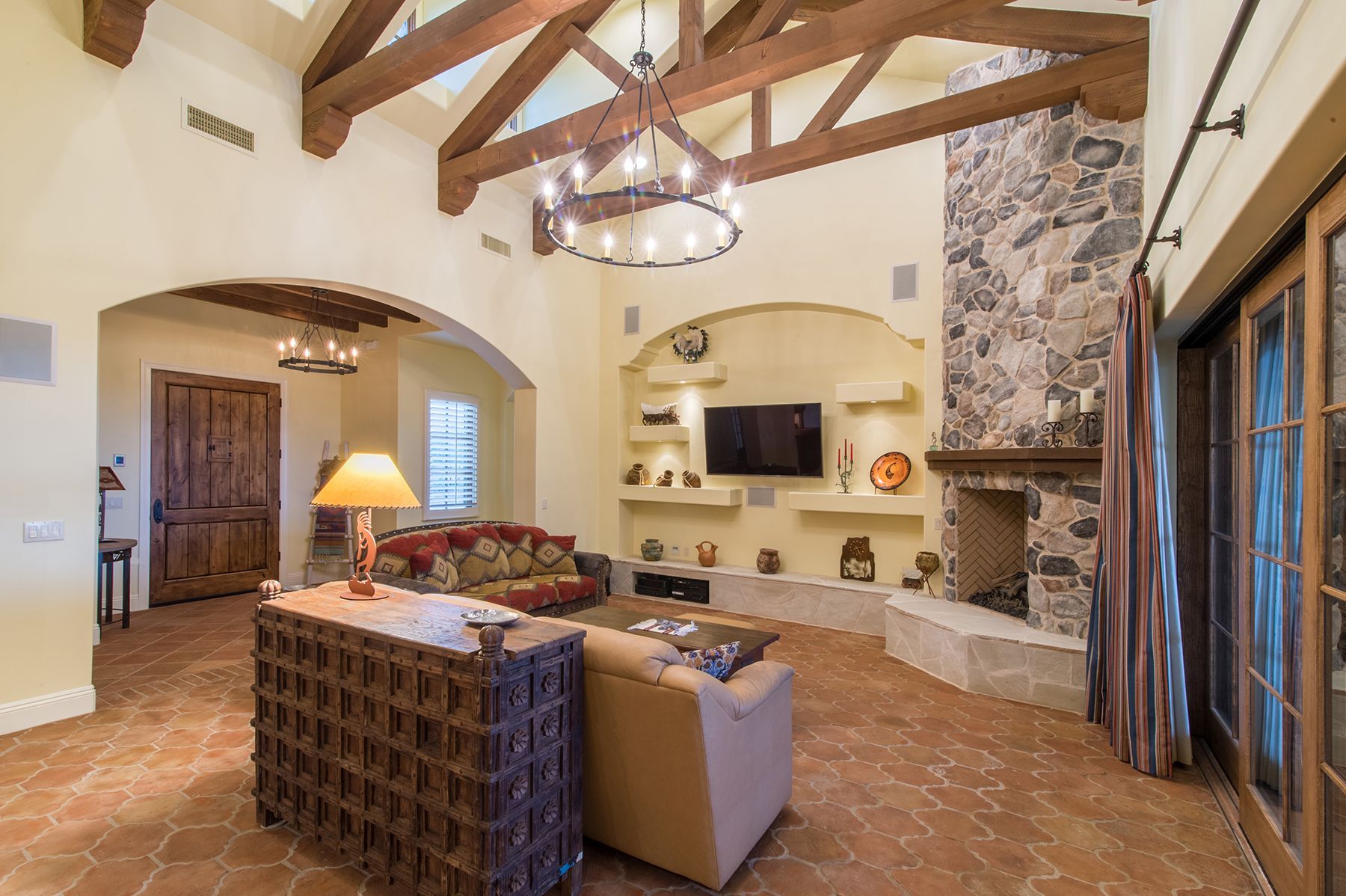 A living room with a fireplace , couch , chair and television.