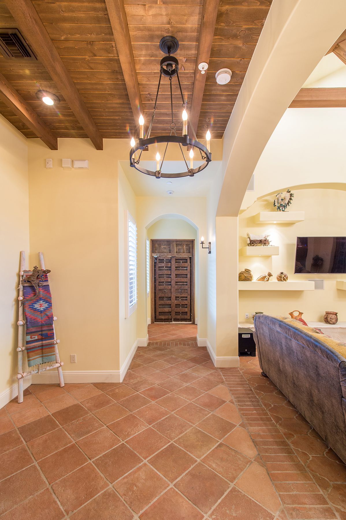 A hallway in a house with a chandelier hanging from the ceiling.
