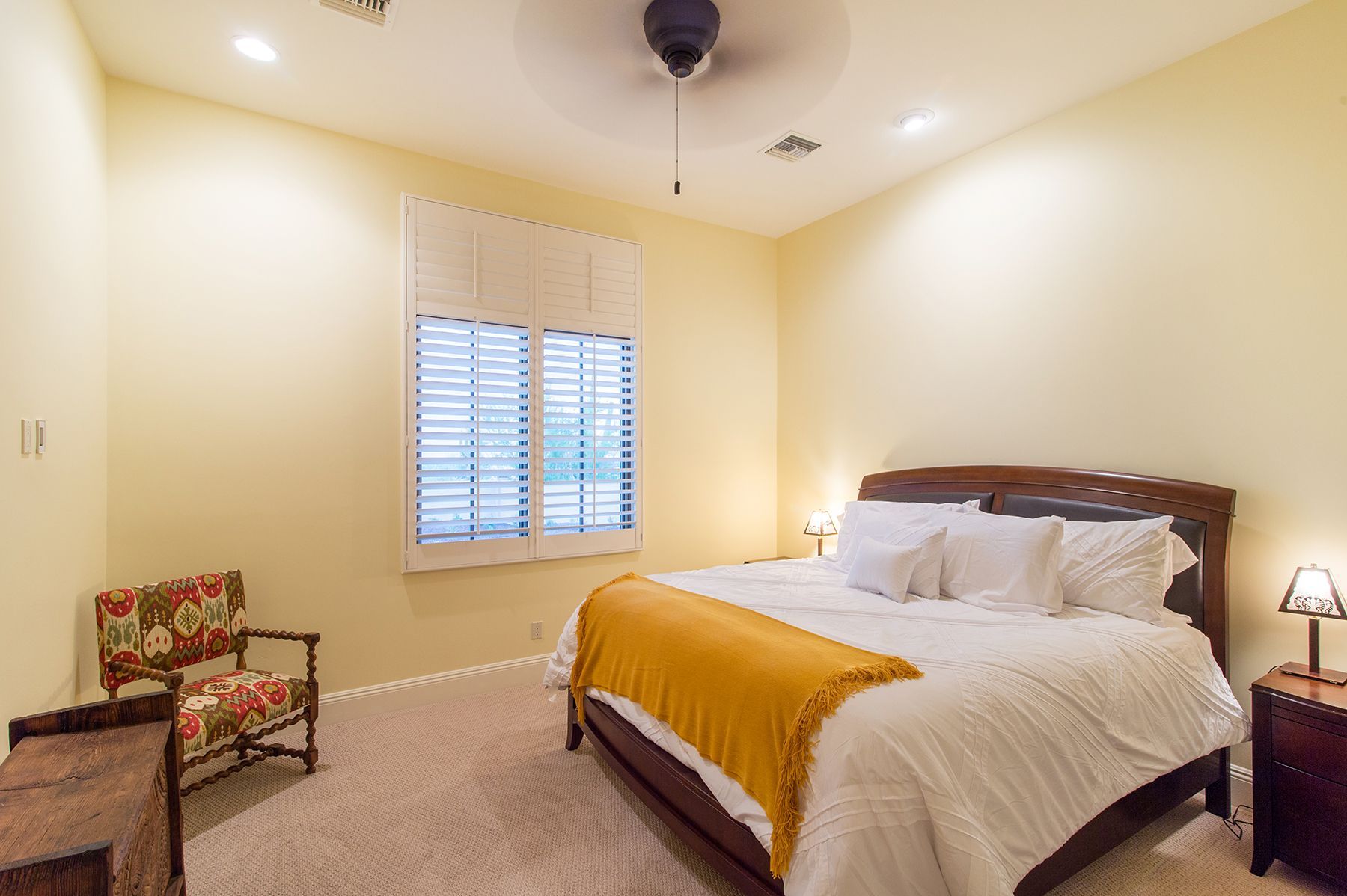 A bedroom with a king size bed and a chair