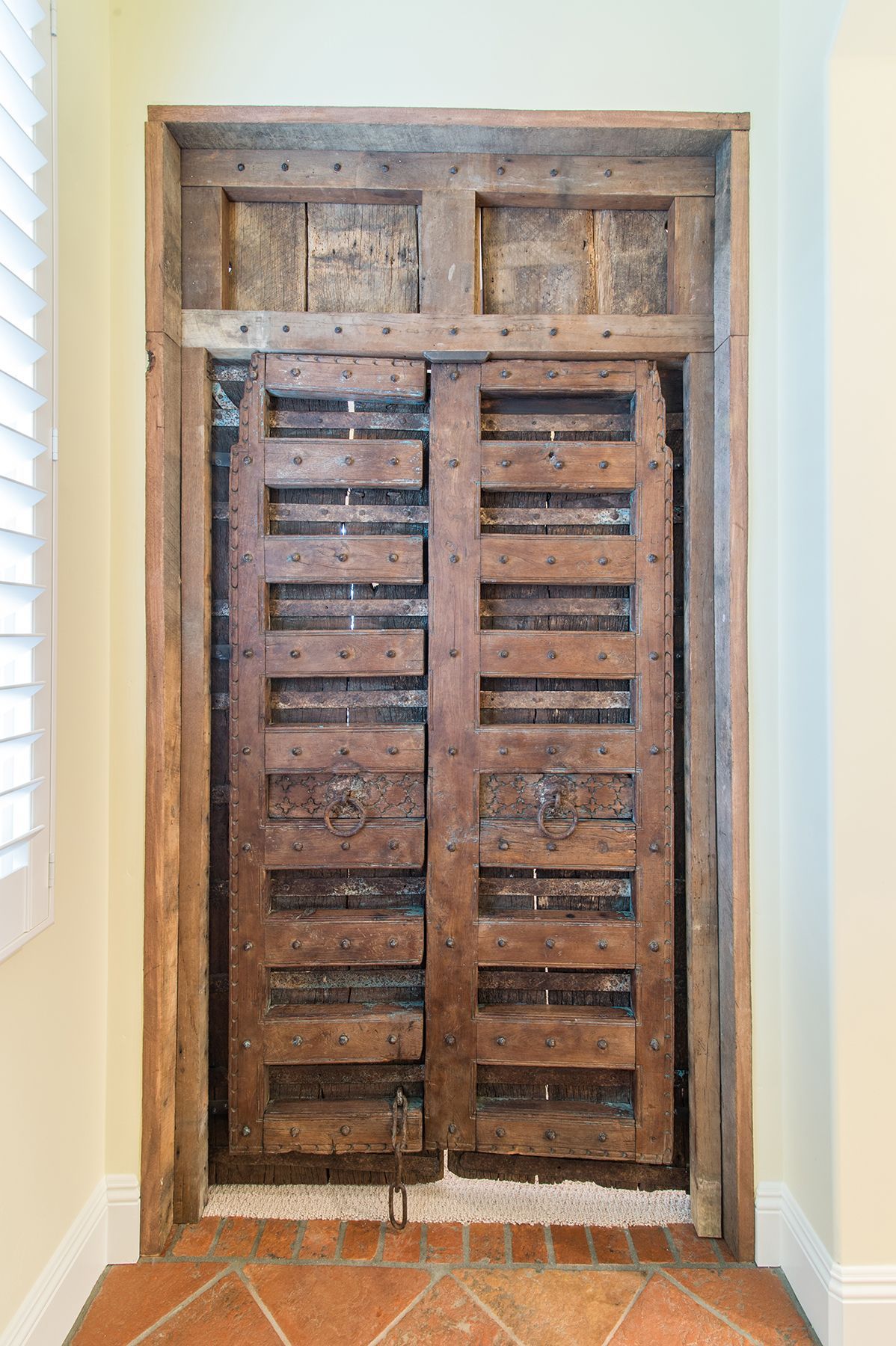 A wooden door is sitting in a room next to a window.
