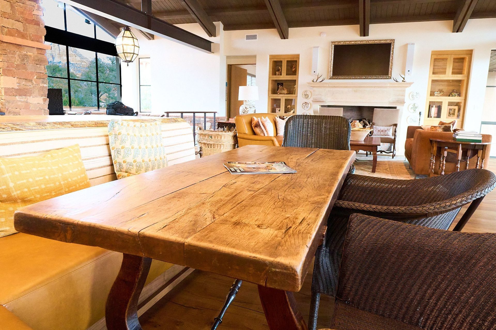 A wooden table with wicker chairs in a living room