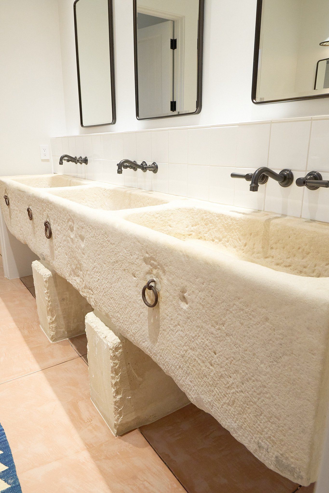 A bathroom with three sinks and three mirrors.