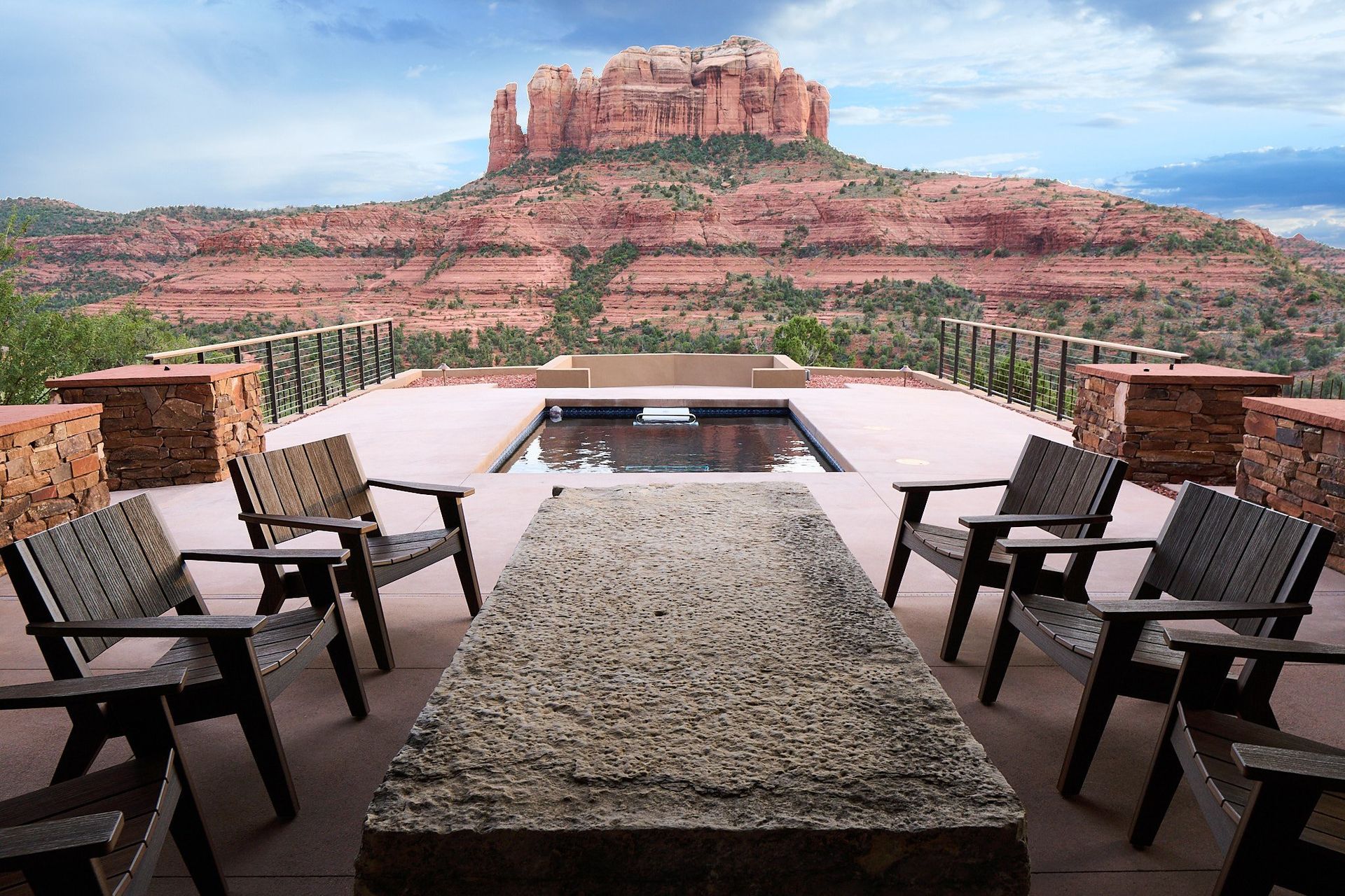 A patio with chairs and a table with a mountain in the background