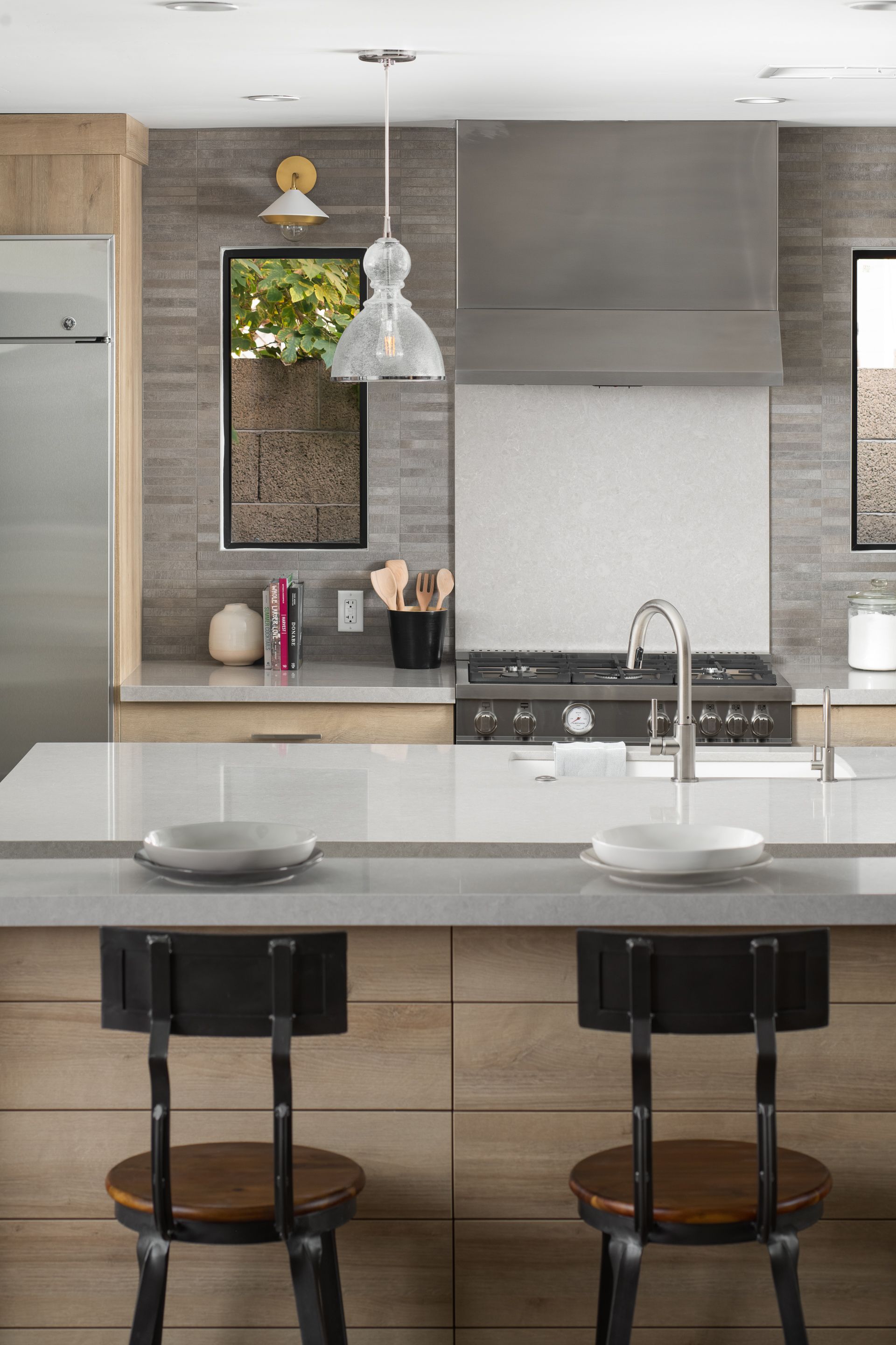 A kitchen with a large island and two stools