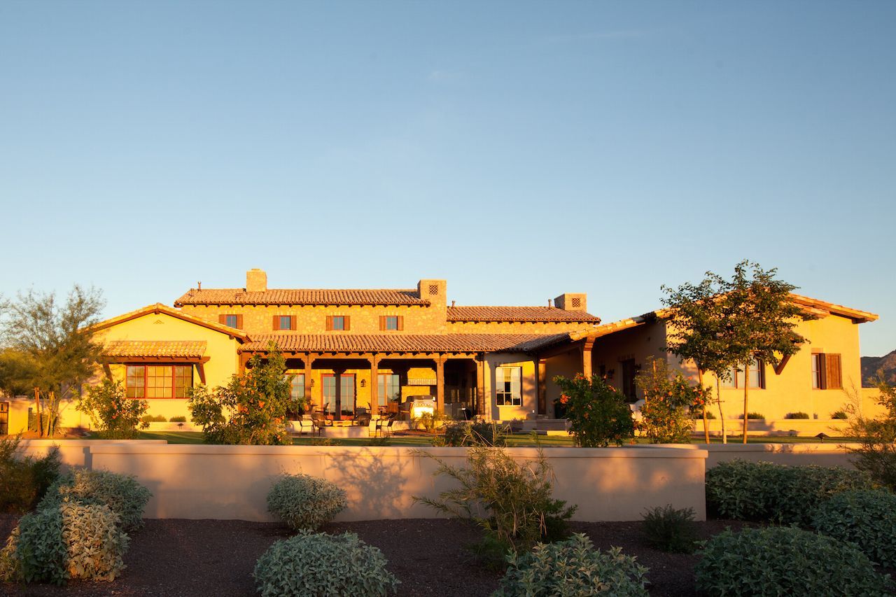 A large house with a lot of plants in front of it