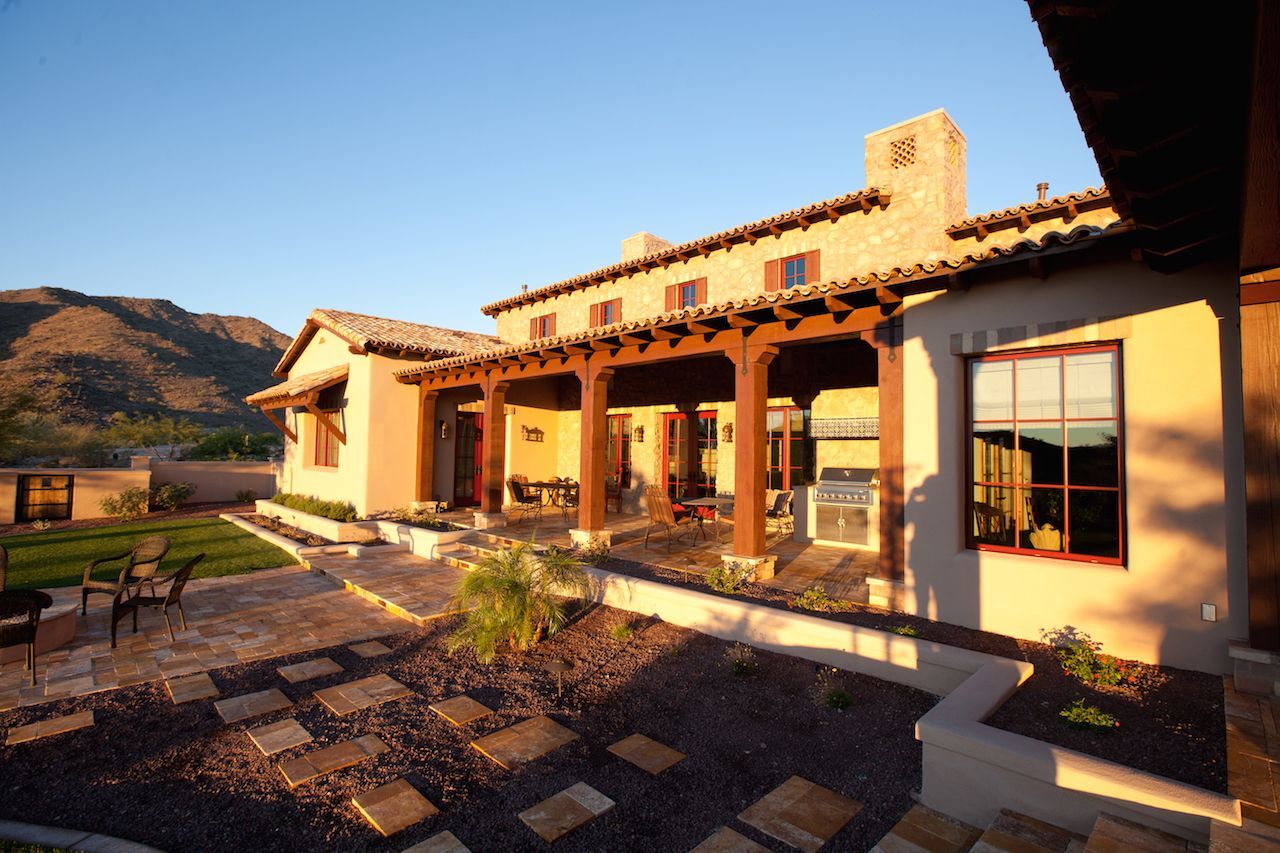 A large house with a patio and mountains in the background