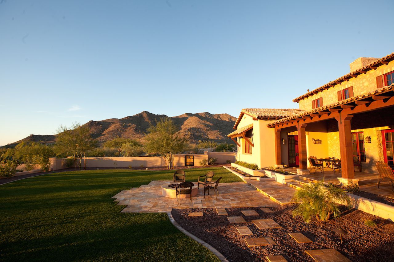 A large house with a patio and mountains in the background