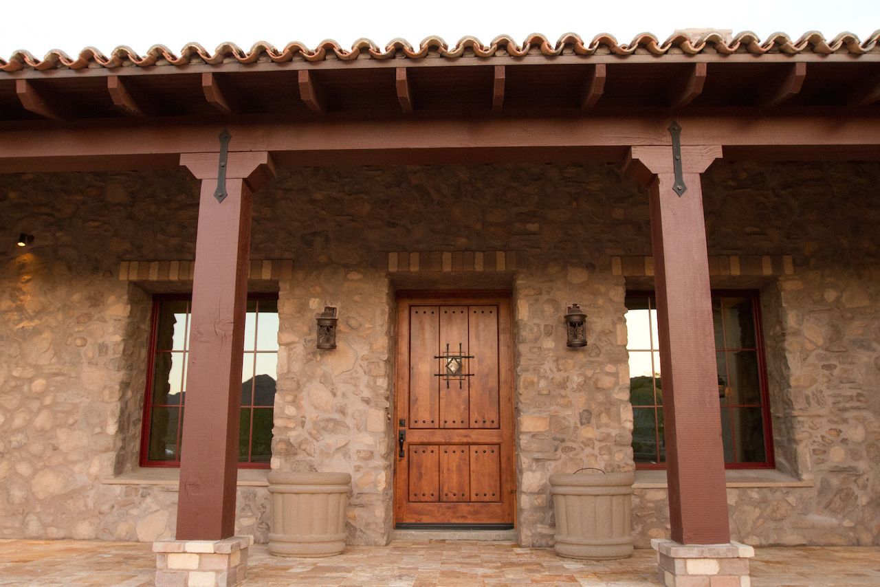 The front door of a stone house with a wooden door