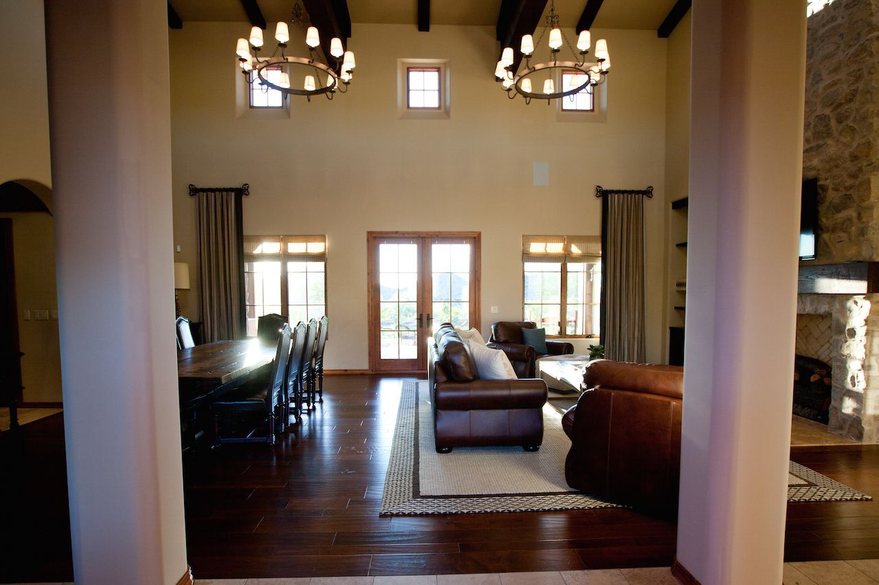 A living room with a lot of furniture and a dining room in the background