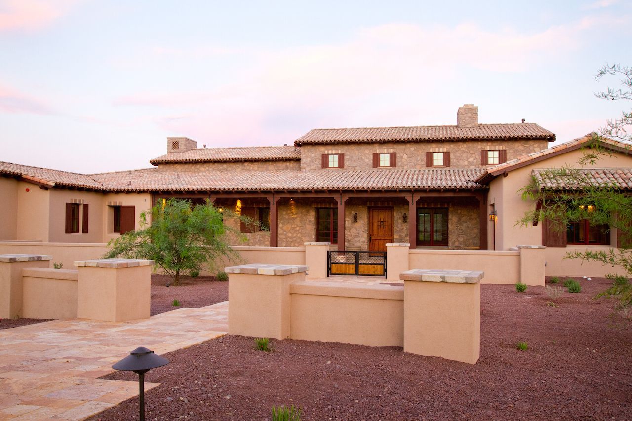 A large house with a stone roof and a walkway leading to it.