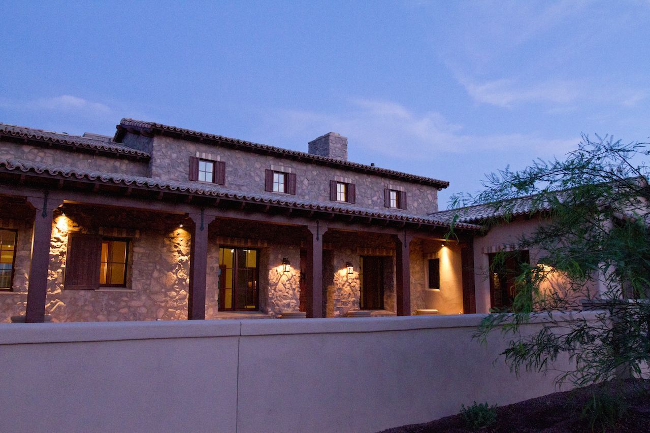 A large house with a lot of windows is lit up at night.