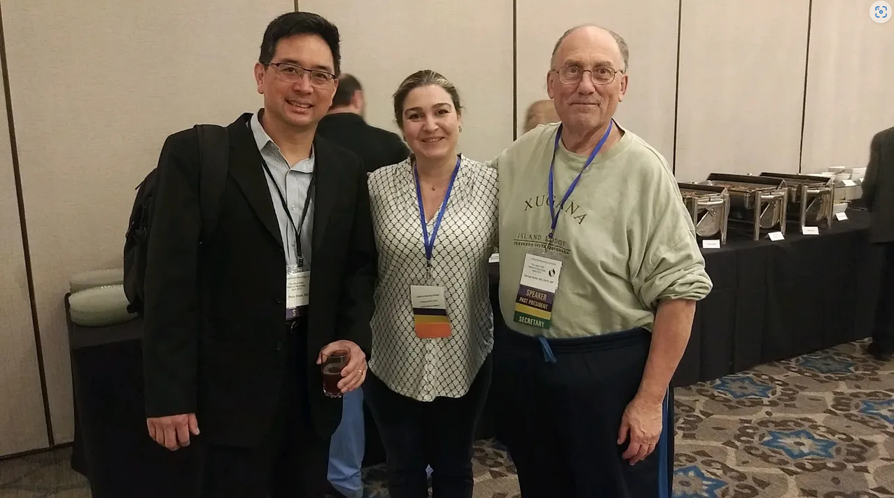 2 Board members take photo with an attendee