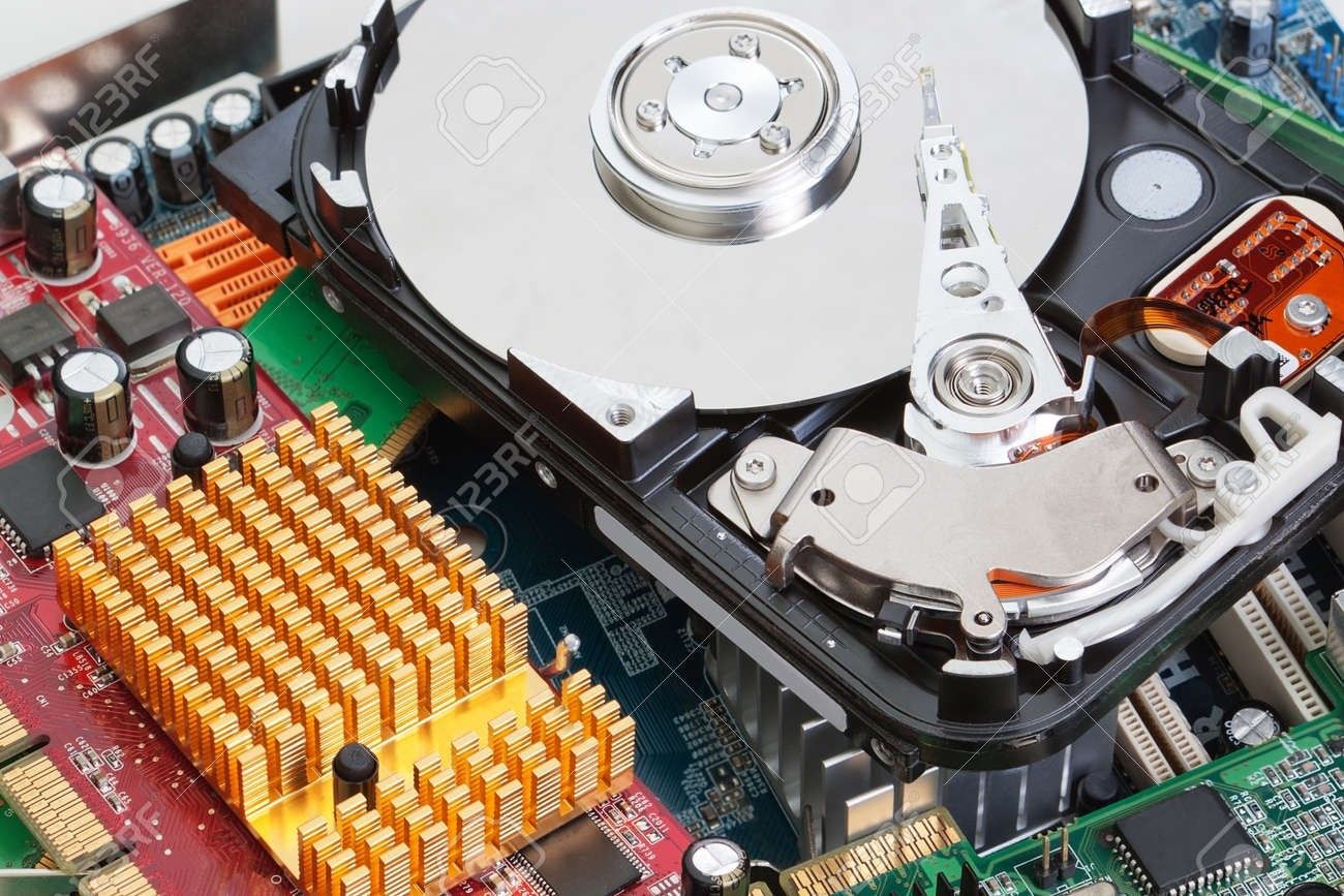 Close-up of a hard drive circuit board with exposed silver platters and orange heatsinks