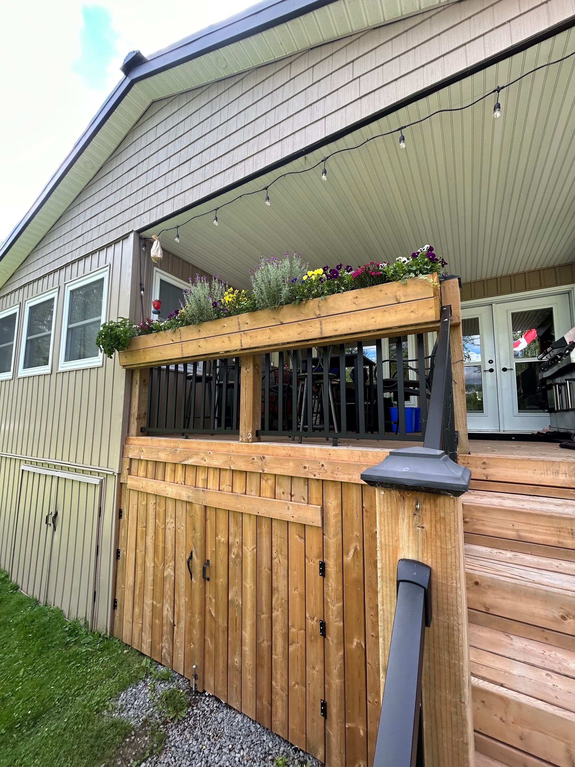 A house with a wooden deck and a wooden fence in front of it.